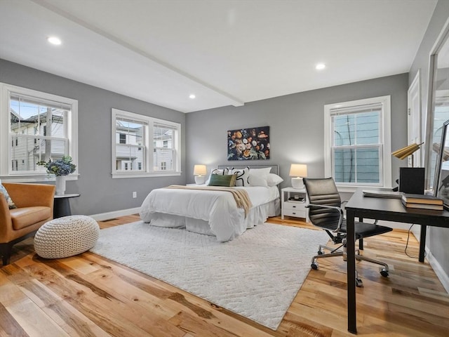 bedroom with hardwood / wood-style flooring and multiple windows