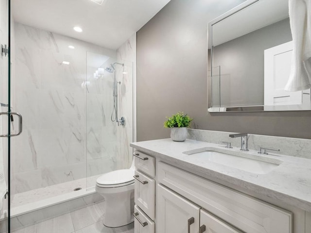 bathroom with a shower with door, vanity, and toilet