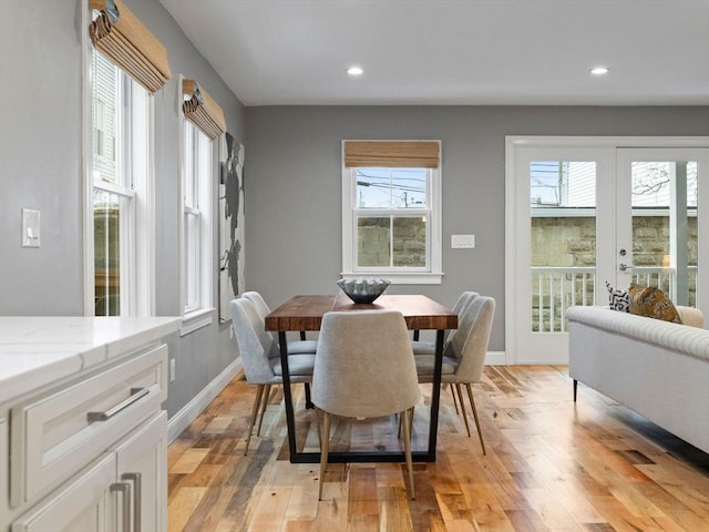 dining space with french doors and light hardwood / wood-style flooring