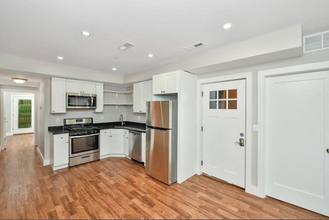 225 Washington, Boston, MA 02121 - kitchen featuring stainless steel appliances, open shelves, dark countertops, light wood-type flooring, and recessed lighting