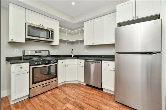 225 Washington, Boston, MA 02121 - kitchen featuring appliances with stainless steel finishes, light wood-style flooring, dark countertops, white cabinets, and recessed lighting