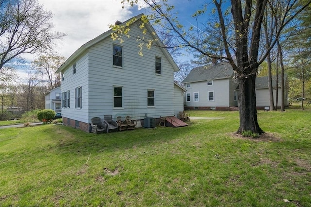 back of property featuring central AC unit and a lawn