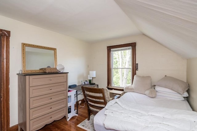 bedroom featuring vaulted ceiling and dark wood-style flooring