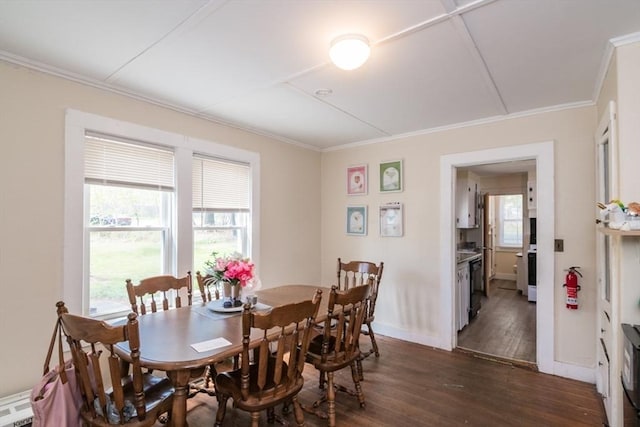 dining room with dark wood-style flooring, crown molding, and baseboards