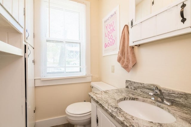 bathroom featuring vanity, toilet, and baseboards