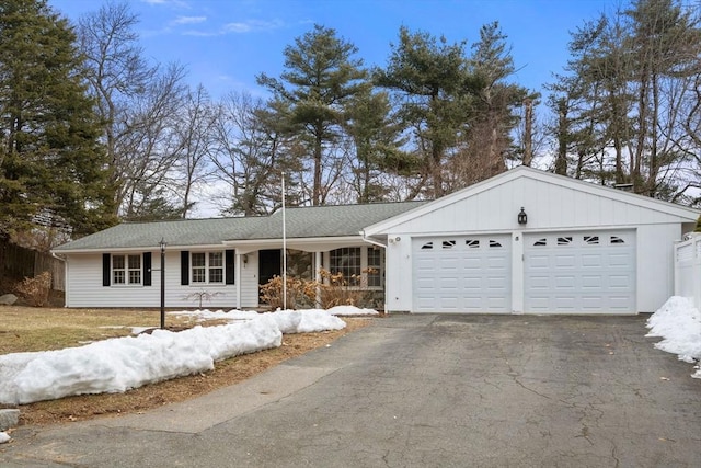 ranch-style home featuring a garage and aphalt driveway