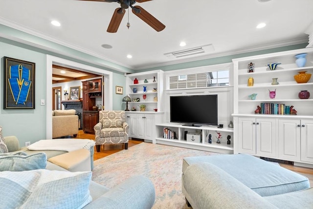 living area featuring ornamental molding, recessed lighting, visible vents, and light wood-style flooring