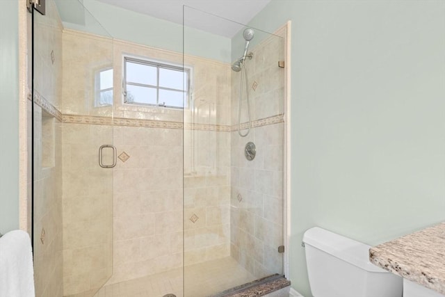 bathroom featuring toilet and a shower stall