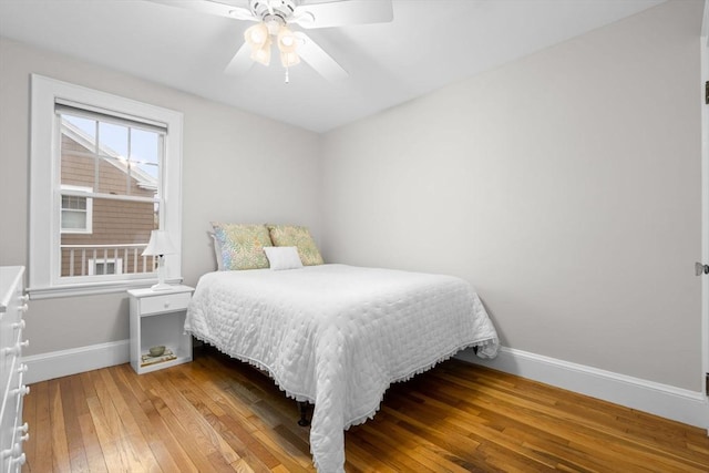 bedroom with a ceiling fan, baseboards, and hardwood / wood-style floors