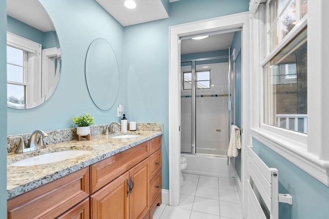 bathroom featuring double vanity, a sink, toilet, and tile patterned floors