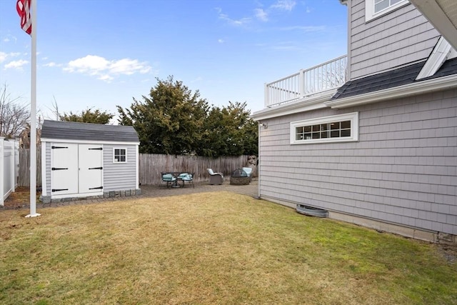 view of yard featuring an outbuilding, a fenced backyard, and a storage unit