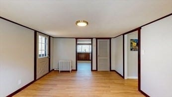 unfurnished room with radiator and light hardwood / wood-style flooring