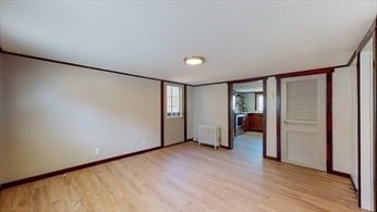 unfurnished bedroom featuring radiator and light hardwood / wood-style floors