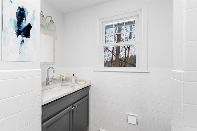 bathroom featuring a wainscoted wall, vanity, and tile walls