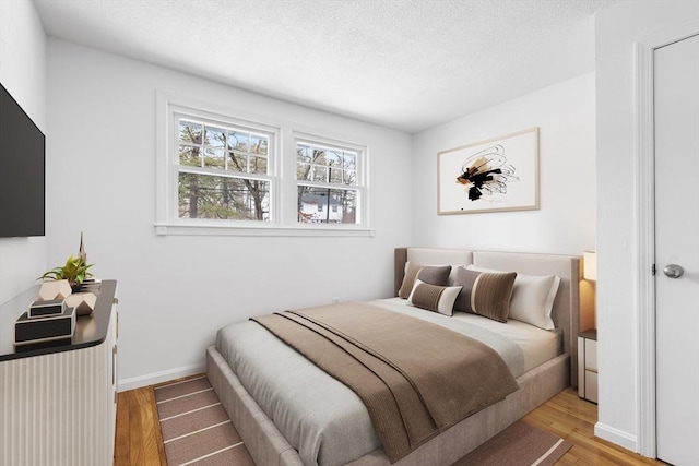 bedroom with baseboards and wood finished floors