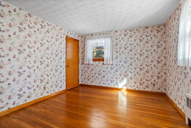 spare room with radiator and hardwood / wood-style flooring