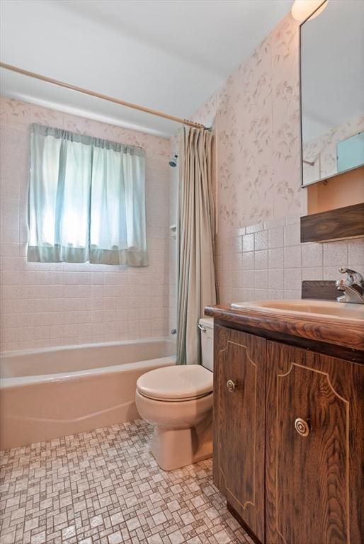 full bathroom featuring shower / bath combination with curtain, vanity, toilet, and tile walls