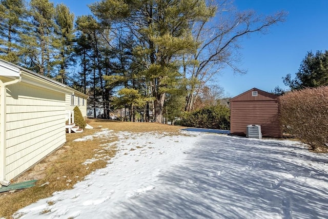 yard layered in snow with a shed