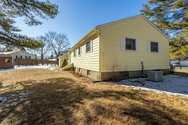 view of side of home featuring a lawn and central air condition unit