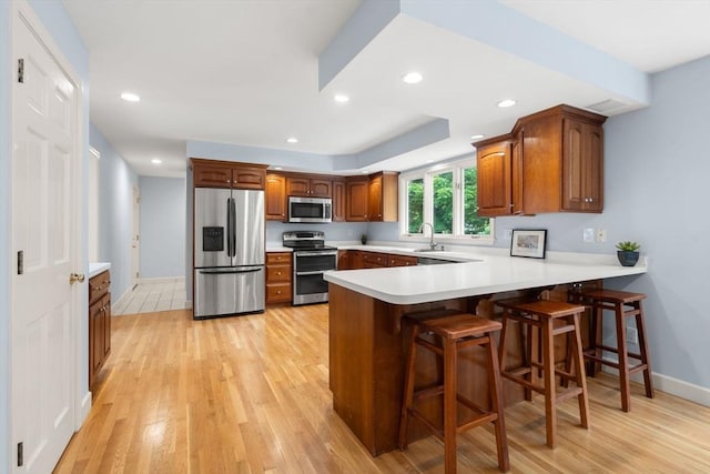 7 Cider Hill Ln, Sherborn, MA 01770 - kitchen with stainless steel appliances, a peninsula, light wood-type flooring, baseboards, and recessed lighting