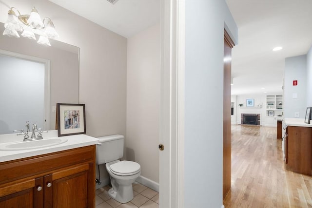 7 Cider Hill Ln, Sherborn, MA 01770 - bathroom with toilet, vanity, wood finished floors, and a fireplace