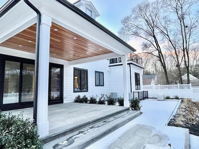 snow covered patio featuring central AC unit