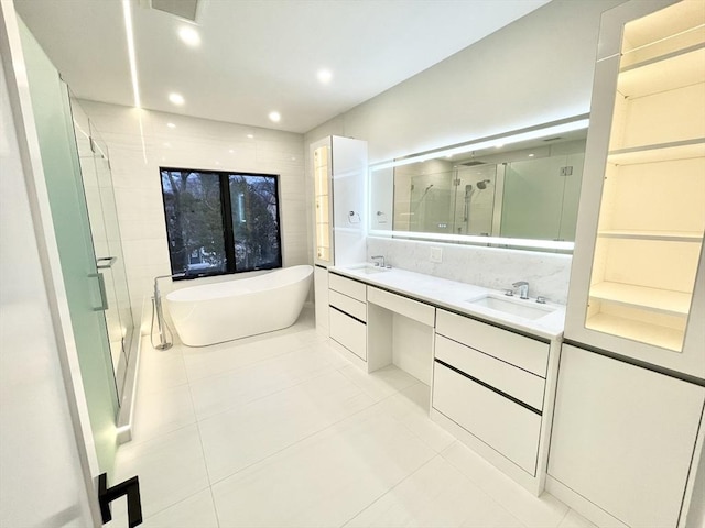 bathroom with independent shower and bath, tile patterned floors, and vanity