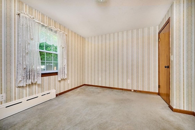 carpeted spare room with baseboard heating, wallpapered walls, and baseboards