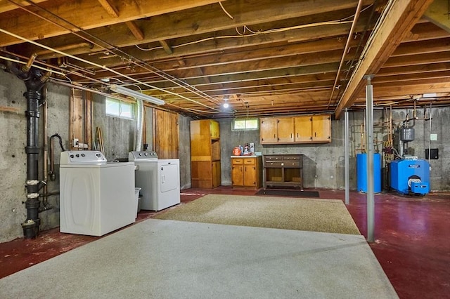 below grade area featuring separate washer and dryer, a heating unit, healthy amount of natural light, and water heater