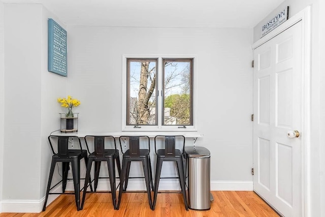 dining space featuring baseboards and light wood finished floors