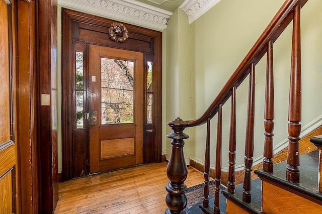 entryway with stairway, baseboards, crown molding, and hardwood / wood-style flooring