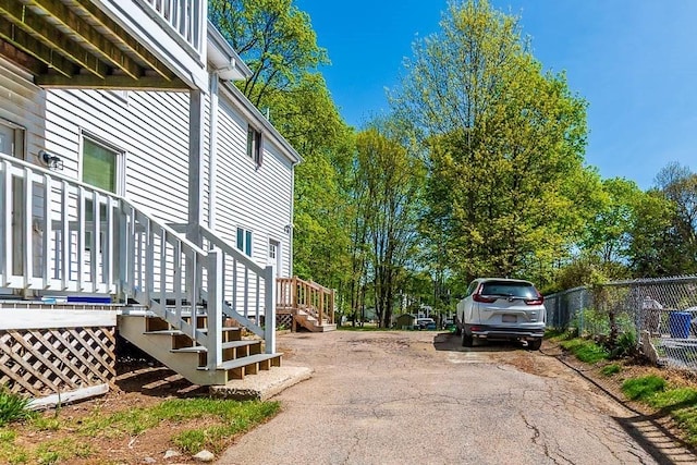 view of property exterior with fence and aphalt driveway