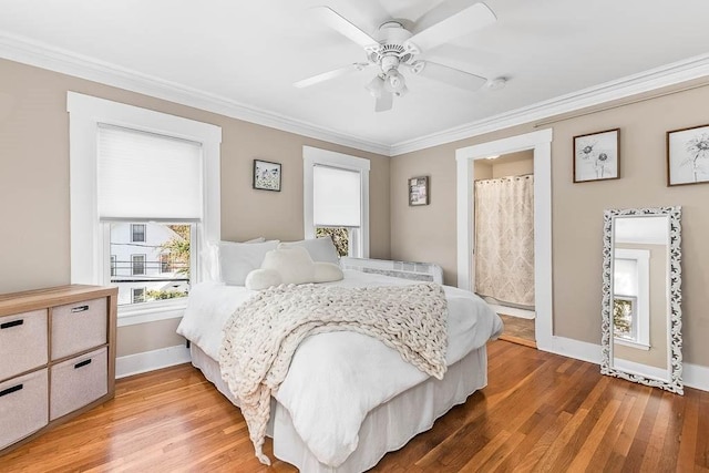 bedroom featuring baseboards, ornamental molding, ceiling fan, and light wood finished floors