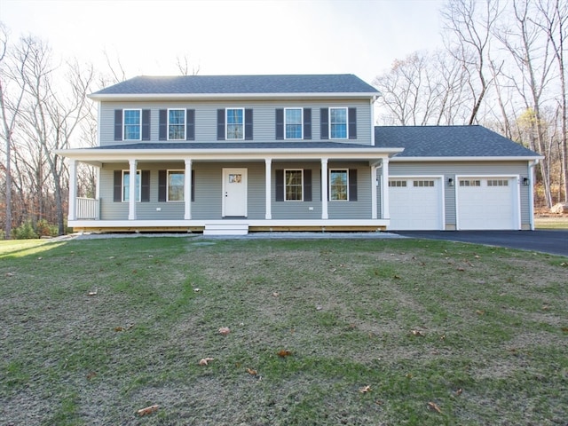 view of front of house featuring a garage, covered porch, and a front yard