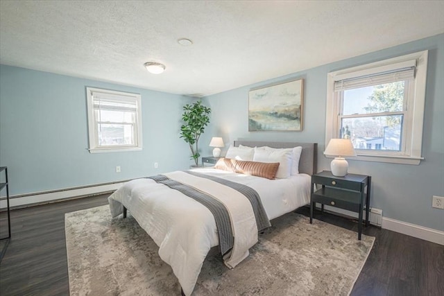 bedroom with dark hardwood / wood-style floors, a baseboard heating unit, a textured ceiling, and multiple windows