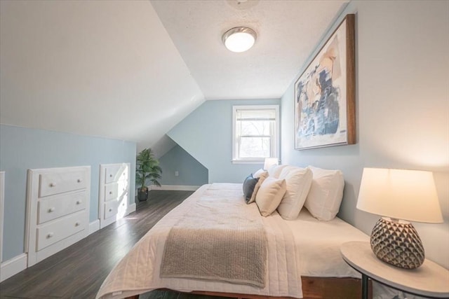 bedroom featuring dark hardwood / wood-style flooring and lofted ceiling