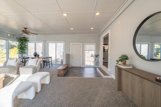 entryway featuring plenty of natural light, dark carpet, and ceiling fan