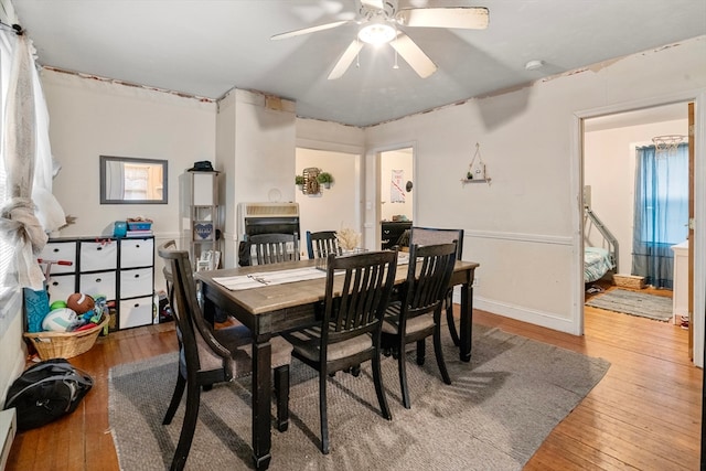 dining room with baseboard heating, ceiling fan, and wood-type flooring