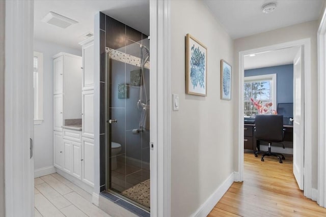 hall featuring baseboards and light wood-style flooring