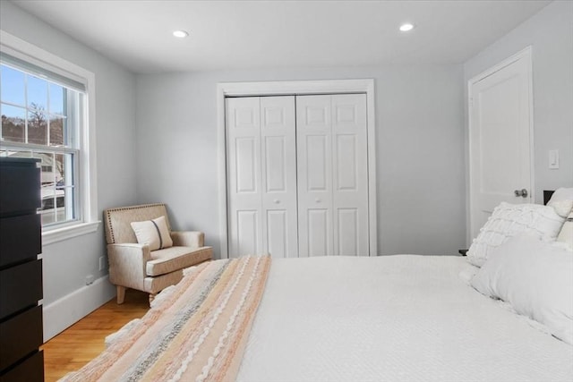 bedroom featuring recessed lighting, wood finished floors, and a closet