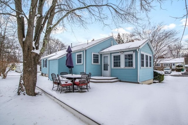 view of snow covered back of property