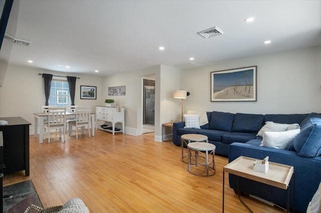 living room featuring recessed lighting, visible vents, light wood-style flooring, and baseboards