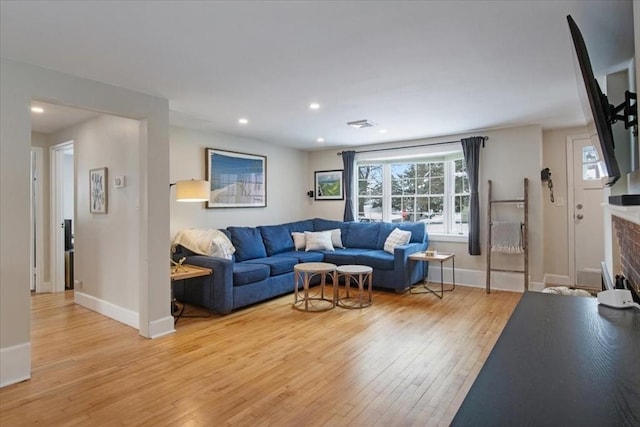 living room with a brick fireplace, light wood-style flooring, recessed lighting, and baseboards