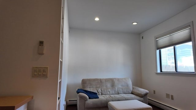 living area featuring a baseboard heating unit and recessed lighting