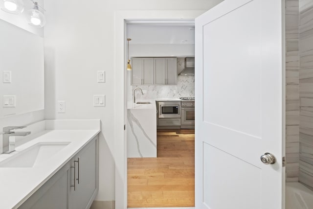 bathroom featuring vanity, backsplash, and hardwood / wood-style floors