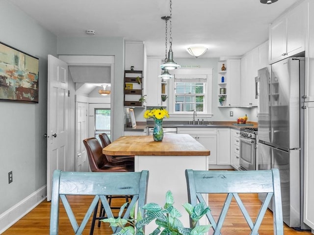 20 Humphrey St, Wakefield, MA 01880 - kitchen featuring stainless steel appliances, open shelves, white cabinets, a center island, and pendant lighting