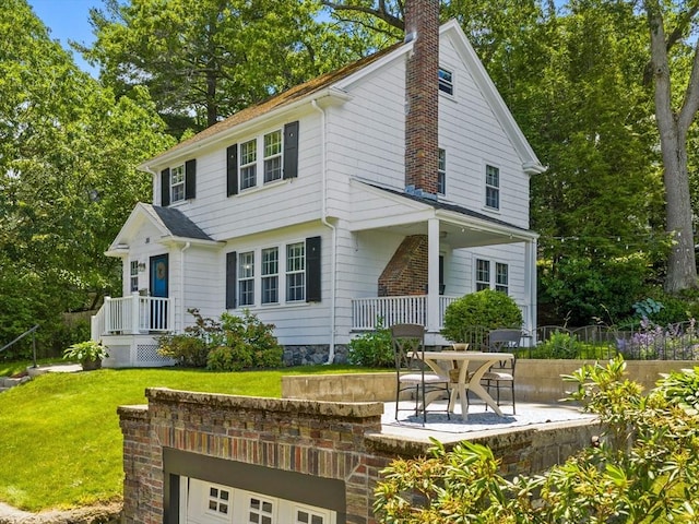 20 Humphrey St, Wakefield, MA 01880 - view of front facade featuring a chimney, a front lawn, and a patio area