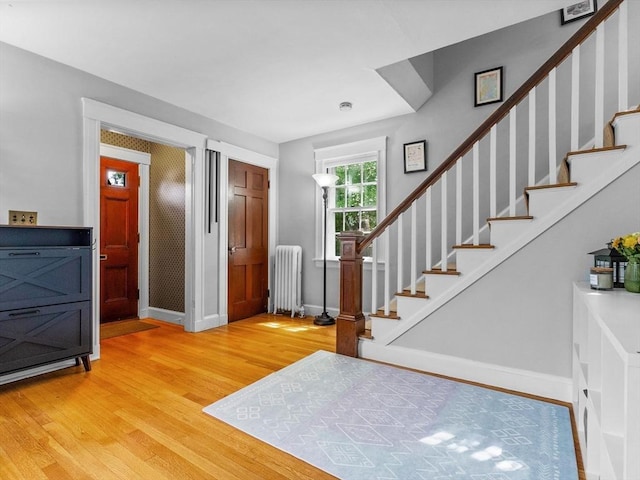 20 Humphrey St, Wakefield, MA 01880 - foyer entrance with radiator heating unit, light wood finished floors, and stairway