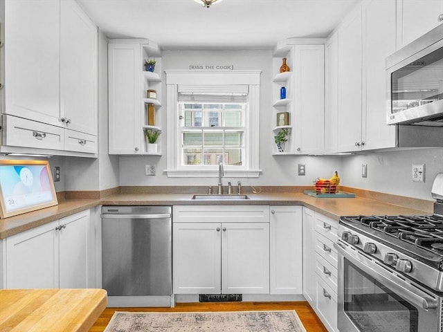 20 Humphrey St, Wakefield, MA 01880 - kitchen with appliances with stainless steel finishes, open shelves, white cabinets, light wood-style flooring, and light countertops