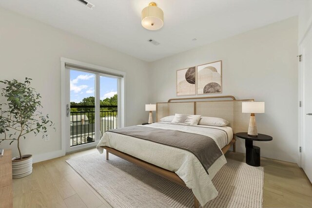 bedroom with visible vents, light wood-style flooring, and access to exterior